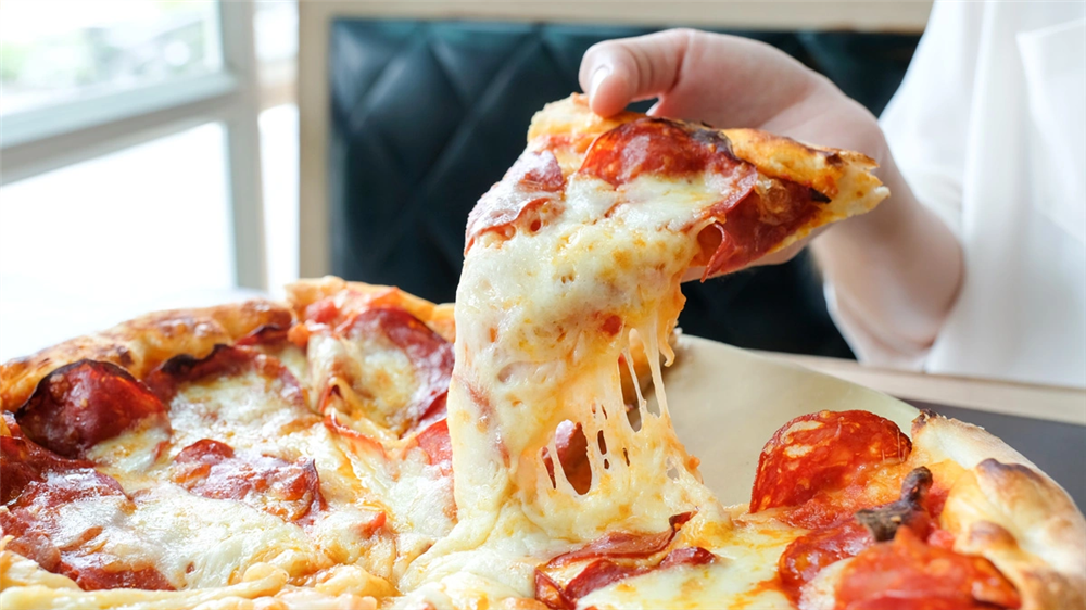 A close-up view of a pepperoni pizza from which someone has cut a slice